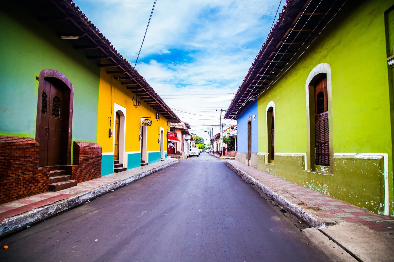 Nicaragua pathway of houses under blue clouds during daytime